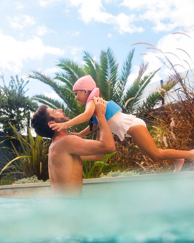 Mann hebt Kind im Wasser hoch