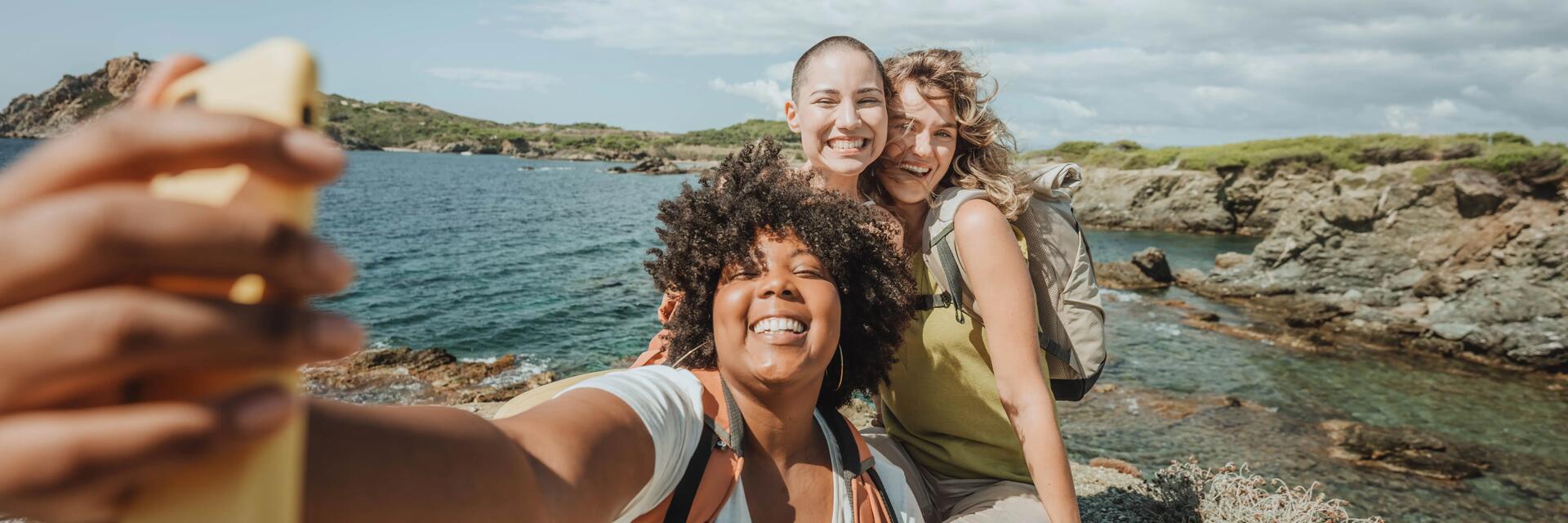 Drei glückliche Frauen machen bei einer Wasserwanderung ein Selfie