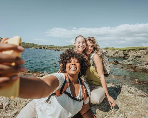 Drei glückliche Frauen machen bei einer Wasserwanderung ein Selfie