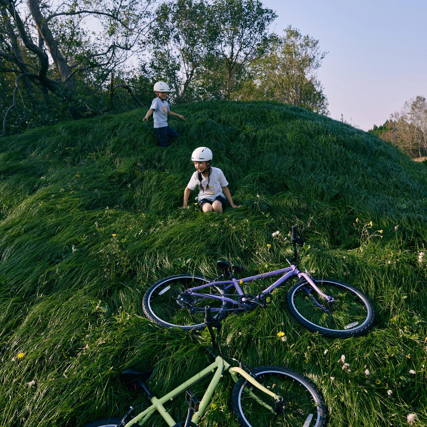 Deti sediace na lúke pred bicyklami