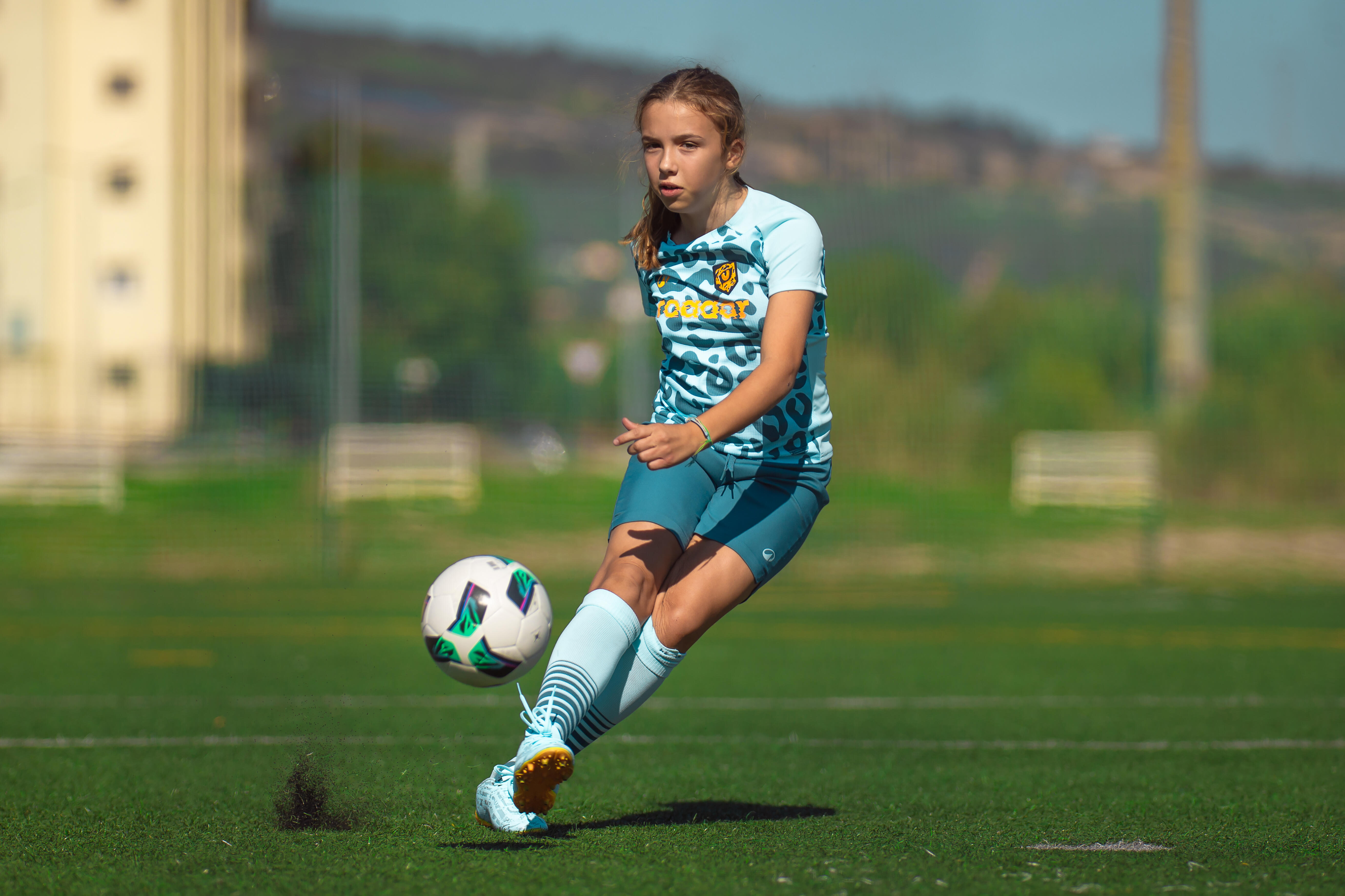 Girl playing soccer on a sports field