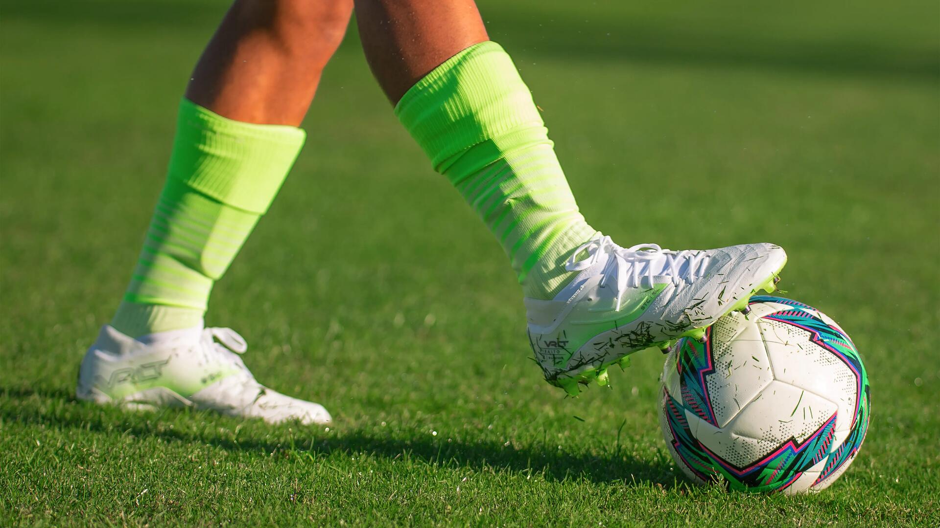 close-up on a player picking up a soccer ball