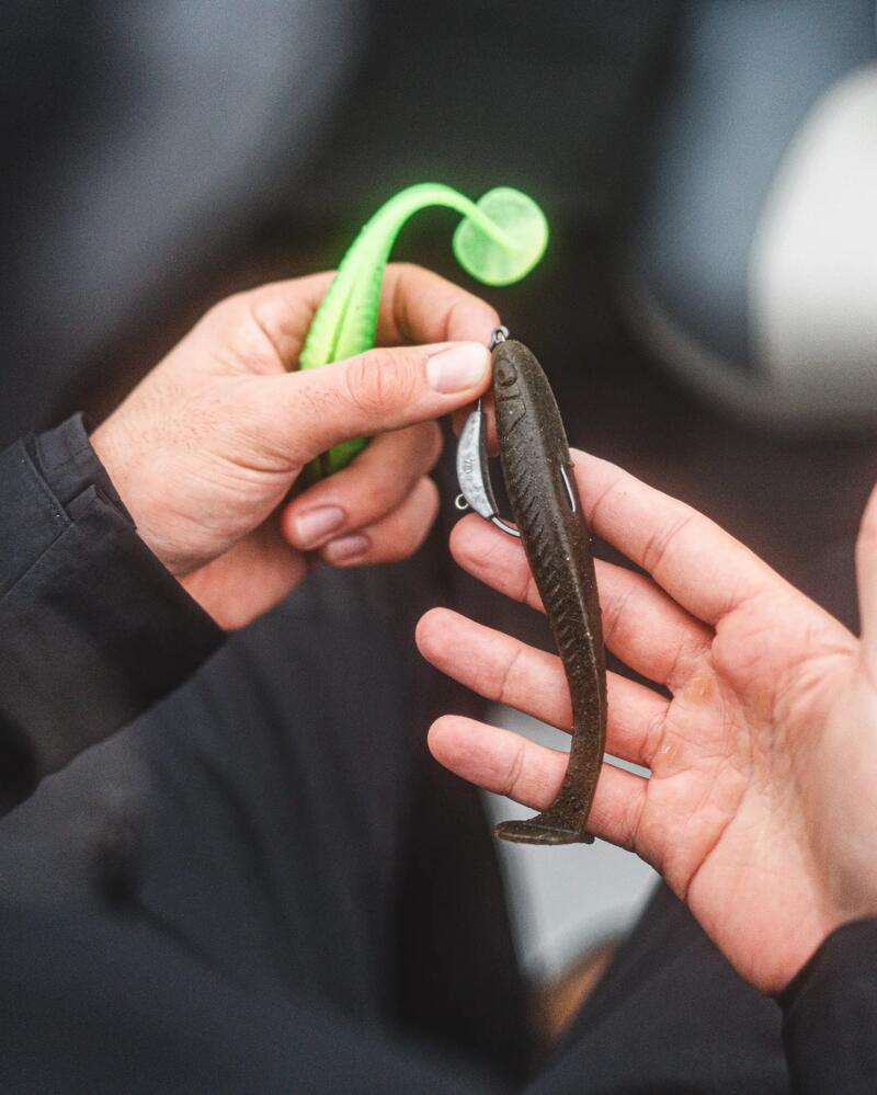 Nahaufnahme von zwei farbigen Gummiködern in der Hand eines Anglers