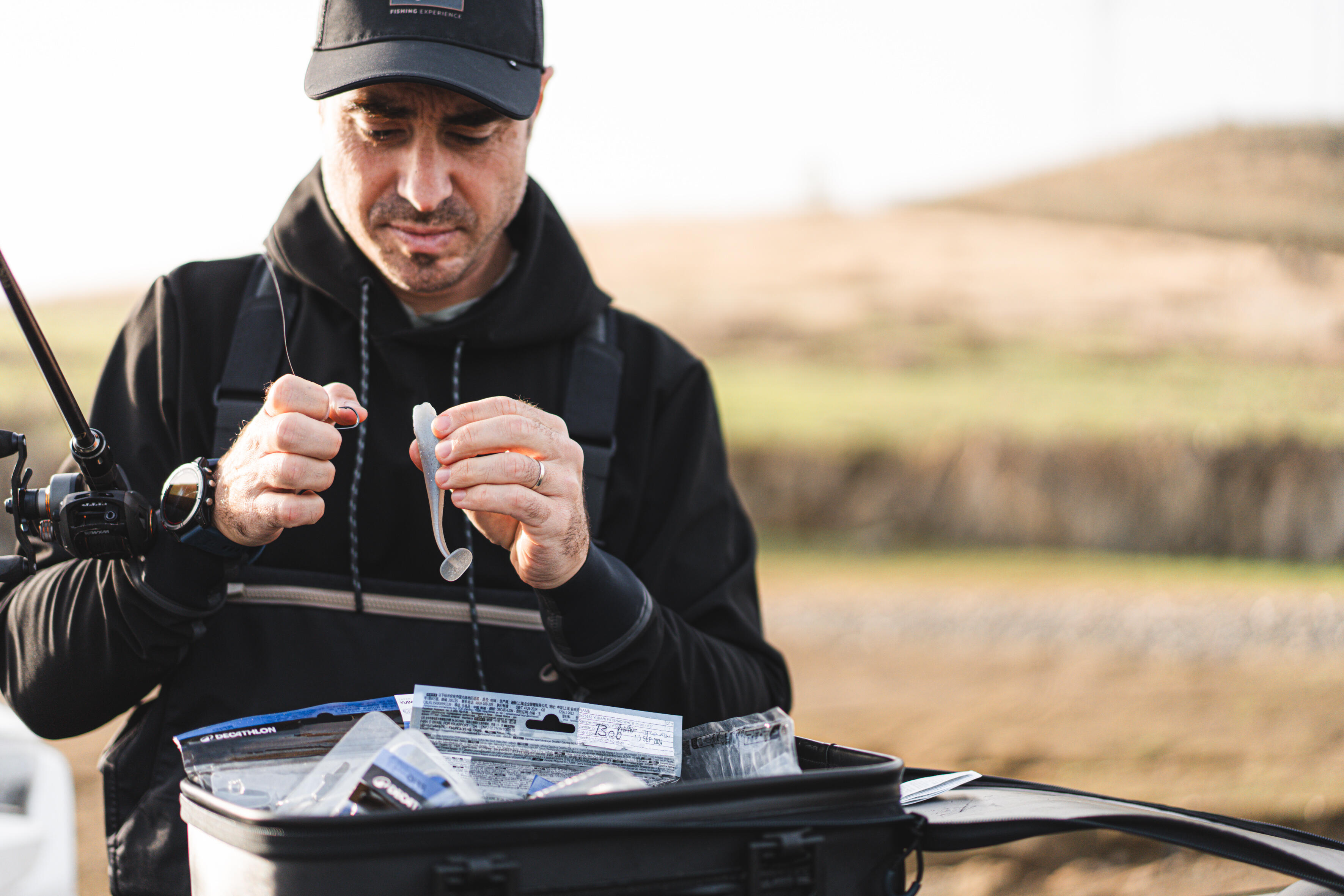 Angler rigging a soft plastic fishing lure before fishing