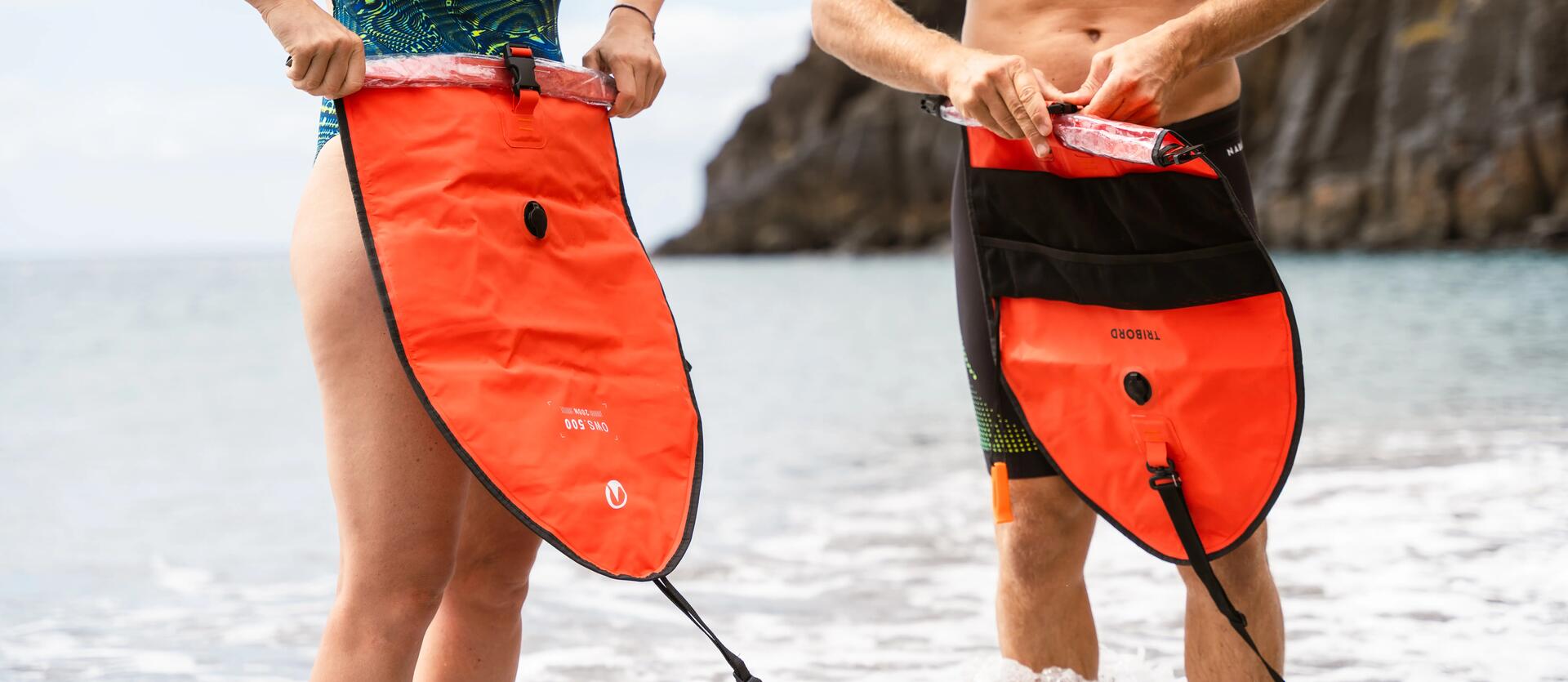 man and woman rolling up their inflatable buoys