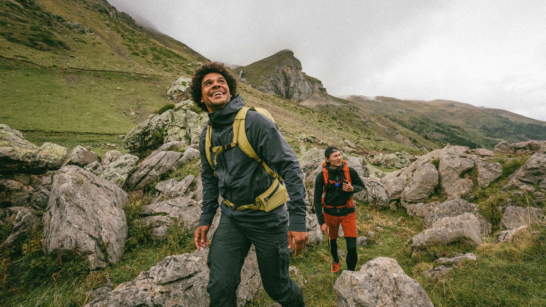 Zwei Wanderer mit Wanderstöcken stehen im Gebirge