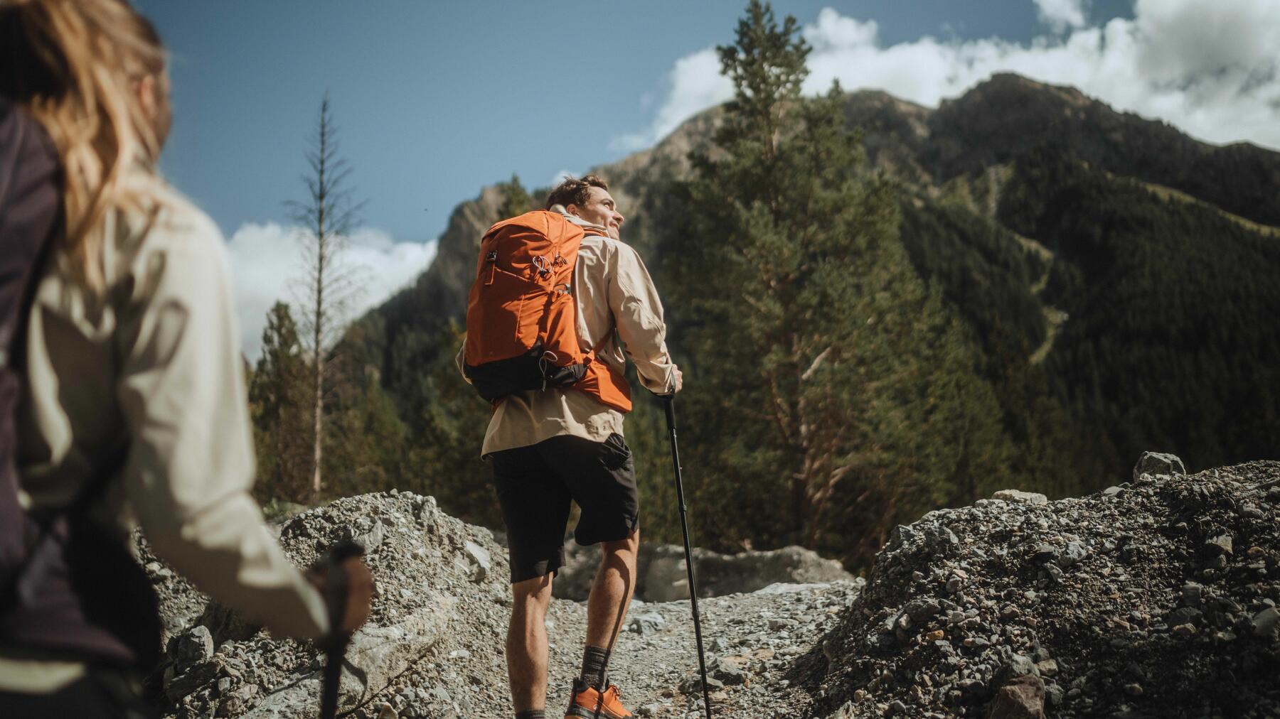 Osoby w odzieży trekkingowej wędrujące po górach