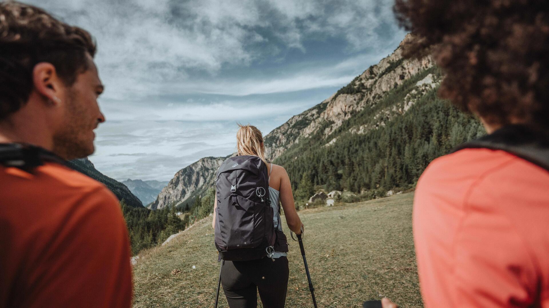 Osoby w odzieży trekkingowej wędrujące po górach