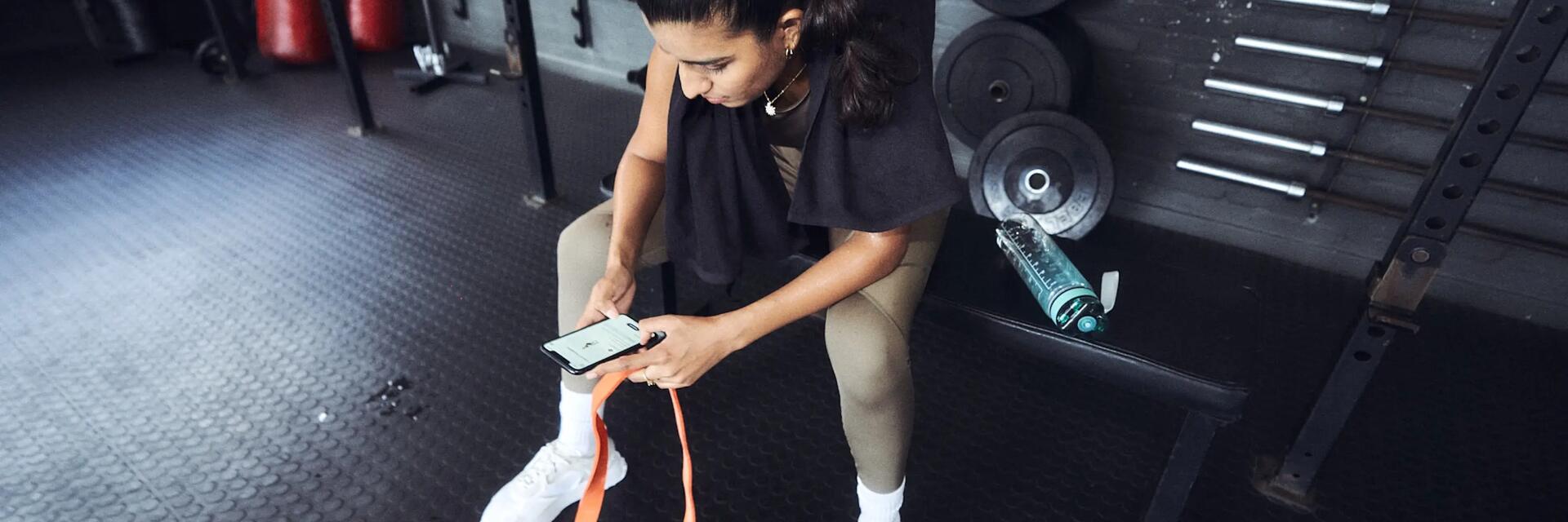Vrouw gebruikt de Freeletics app in de gym