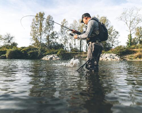 Pêcheur avec un poisson au bout de la canne