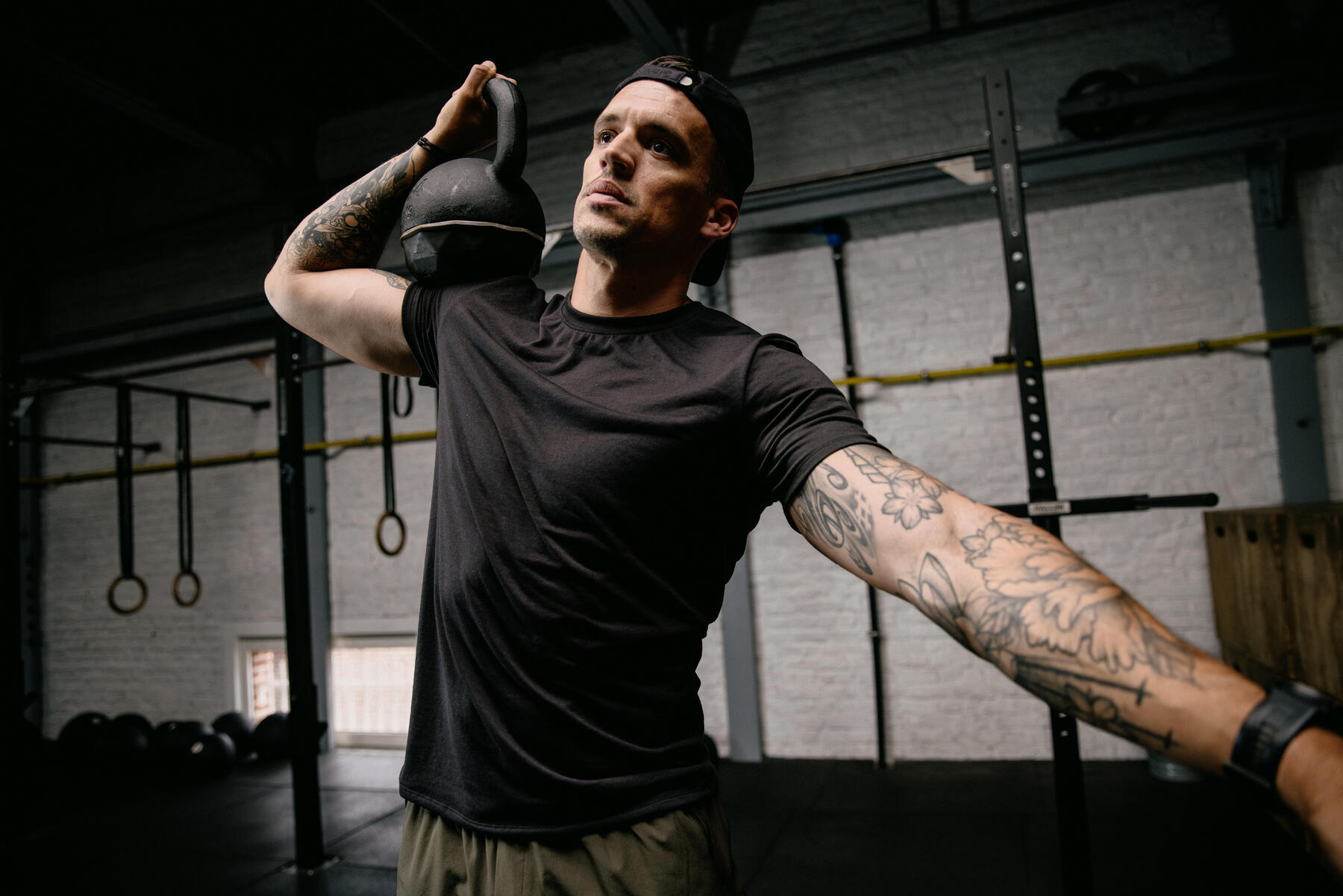 Mężczyzna w odzieży sportowej ćwiczący z kettlebellem