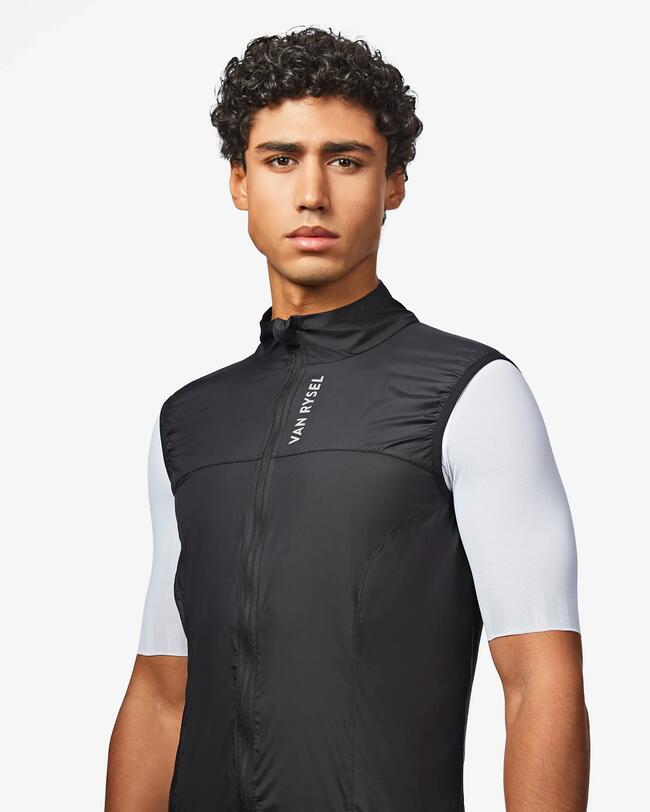 Person in schwarzer Sportkleidung mit weißem Shirt, glatter Stoff, neutraler Hintergrund.
