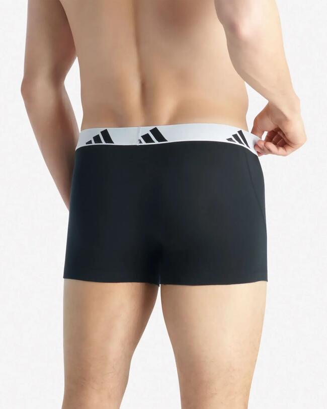 Rückenansicht eines Mannes in schwarzen Boxershorts mit weißem Bund und Adidas-Drei-Streifen-Logo.