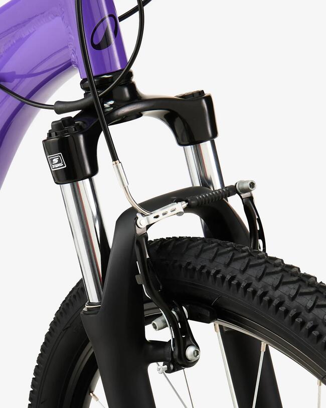Violettes Fahrrad mit schwarzer Gabel, glänzende Metallstreben, grobstolliger Reifen, minimalistisches Design.