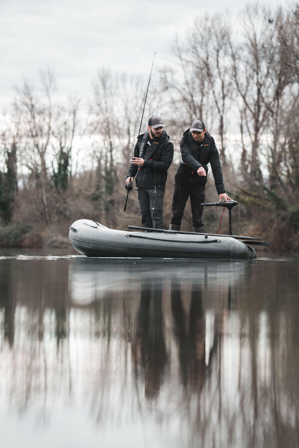 Dva ribiča v gumijastem čolnu na mirnem jezeru.