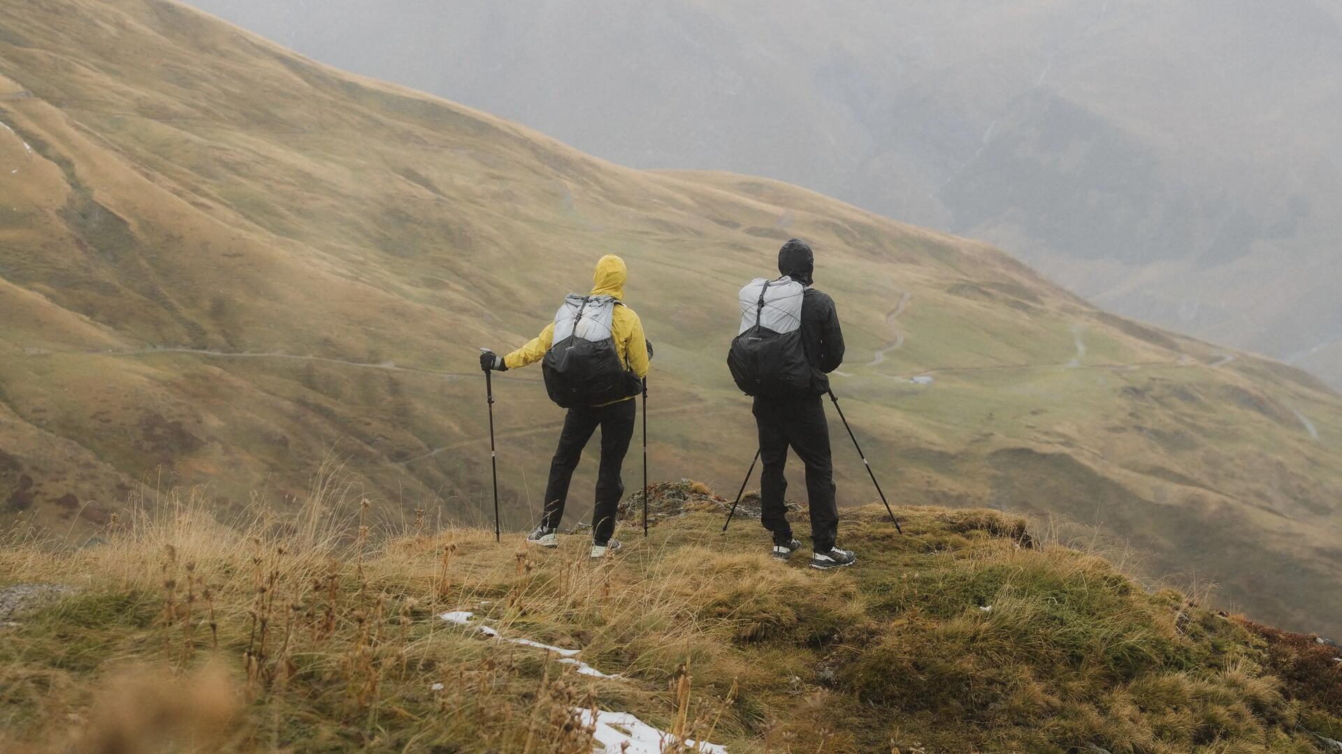 Ludzie z plecakami i z kijkami trekkingowymi wędrujący po górach