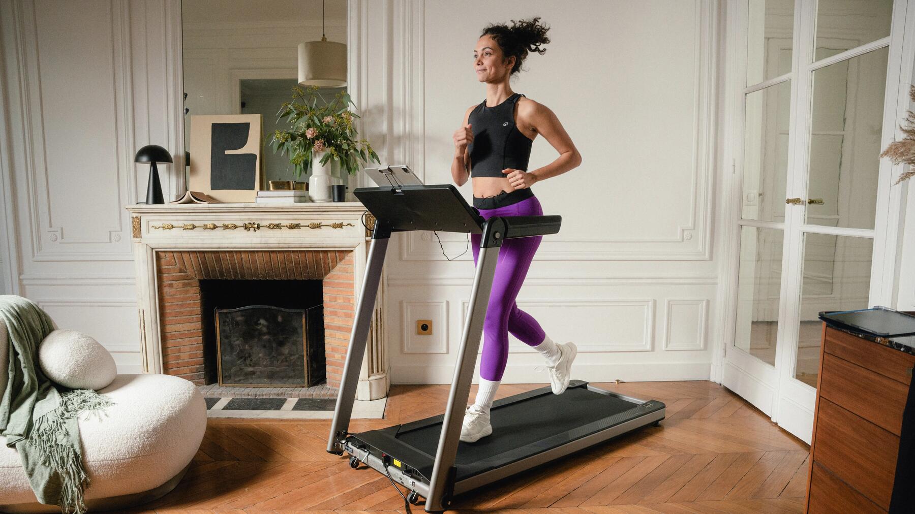Frau beim schnellen Gehen in Fitness Bekleidung und passenden Laufschuhen in ihrem Wohnzimmer