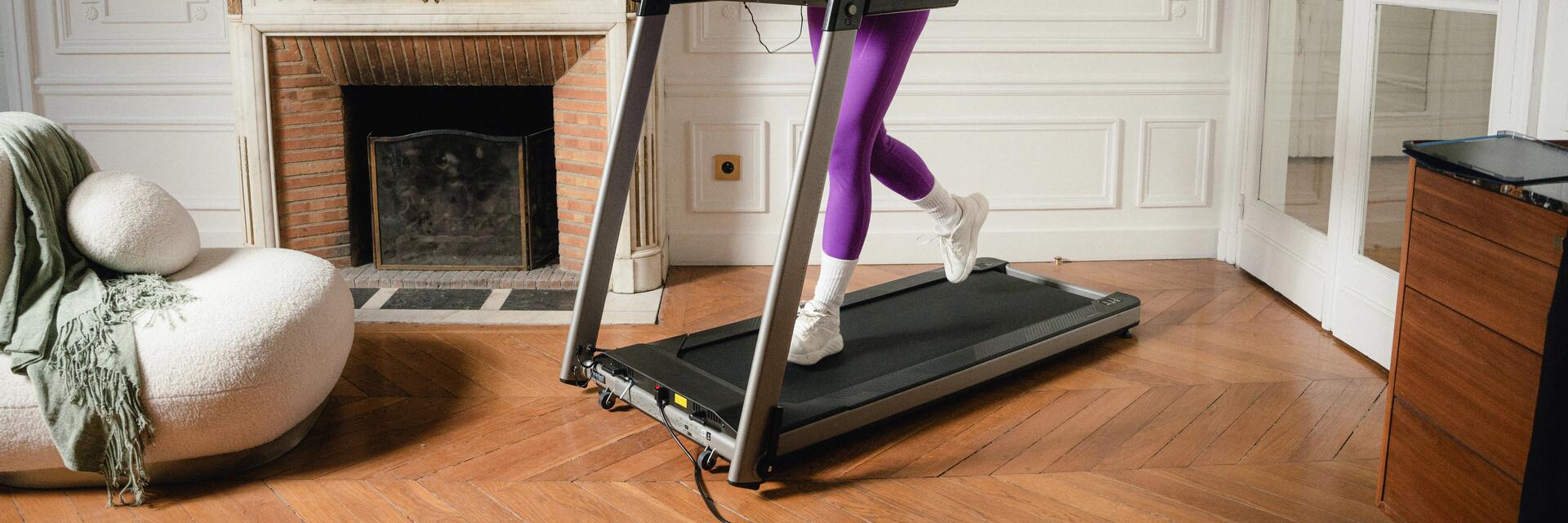 Eine Frau läuft in ihrem Wohnzimmer auf dem Laufband
