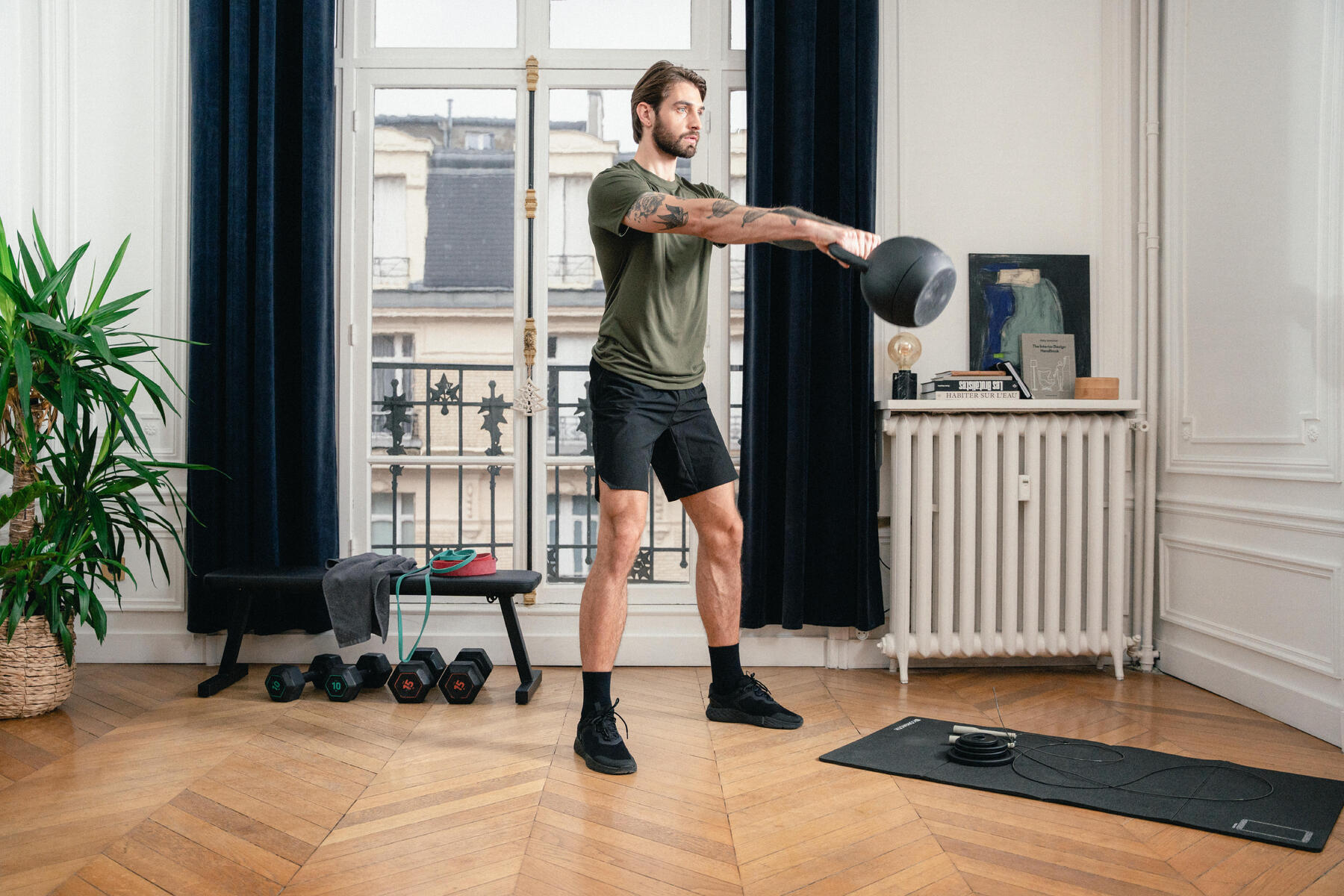 Mężczyzna w stroju sportowym ćwiczący z kettlebell na stojco