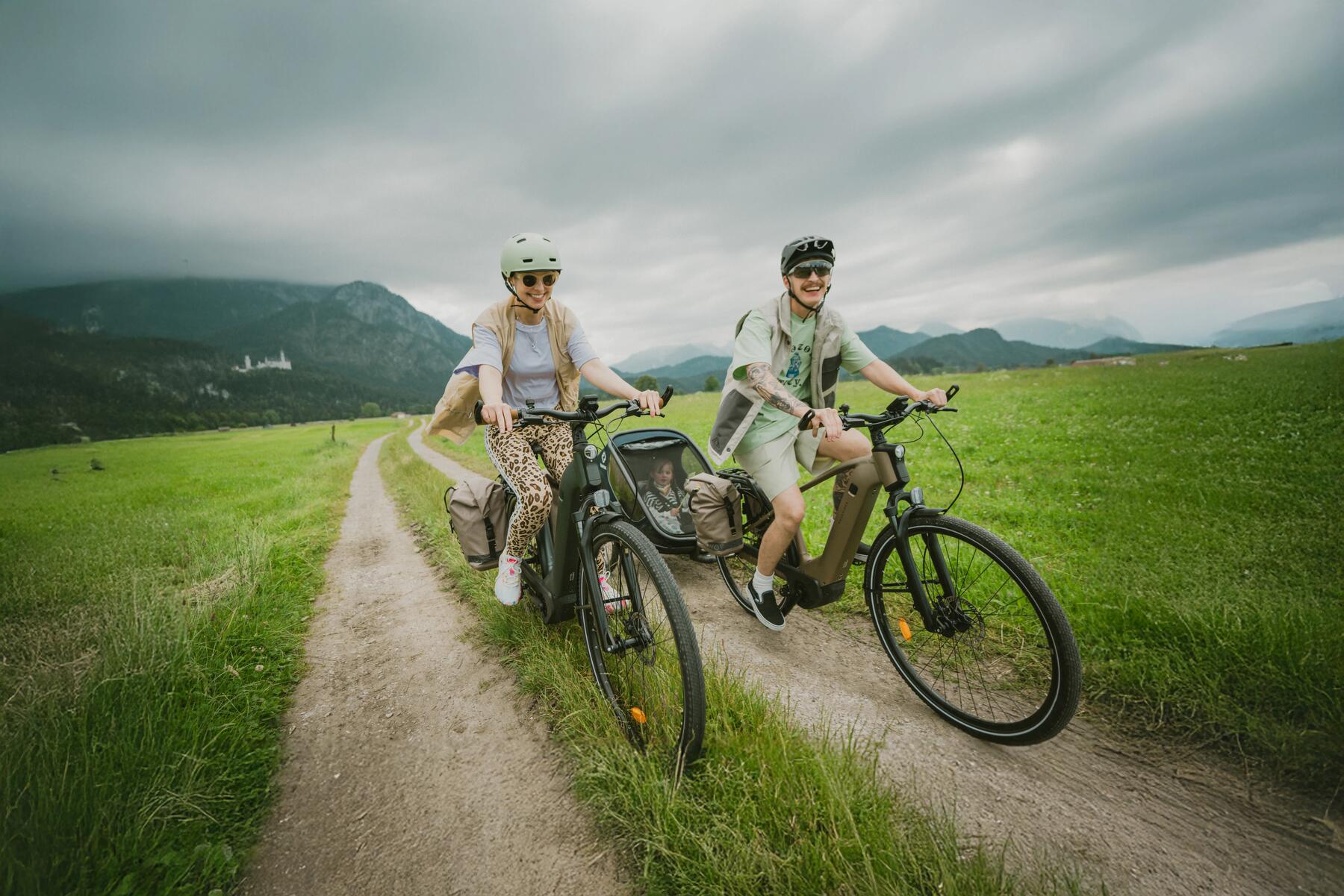 un papa sur son vélo hybride avec son enfant à l'arrière 