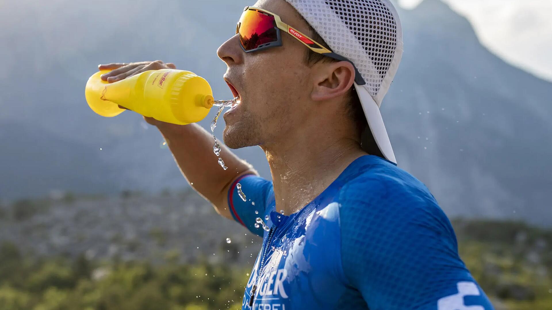 Man die tijdens het sporten via een bidon drinkt