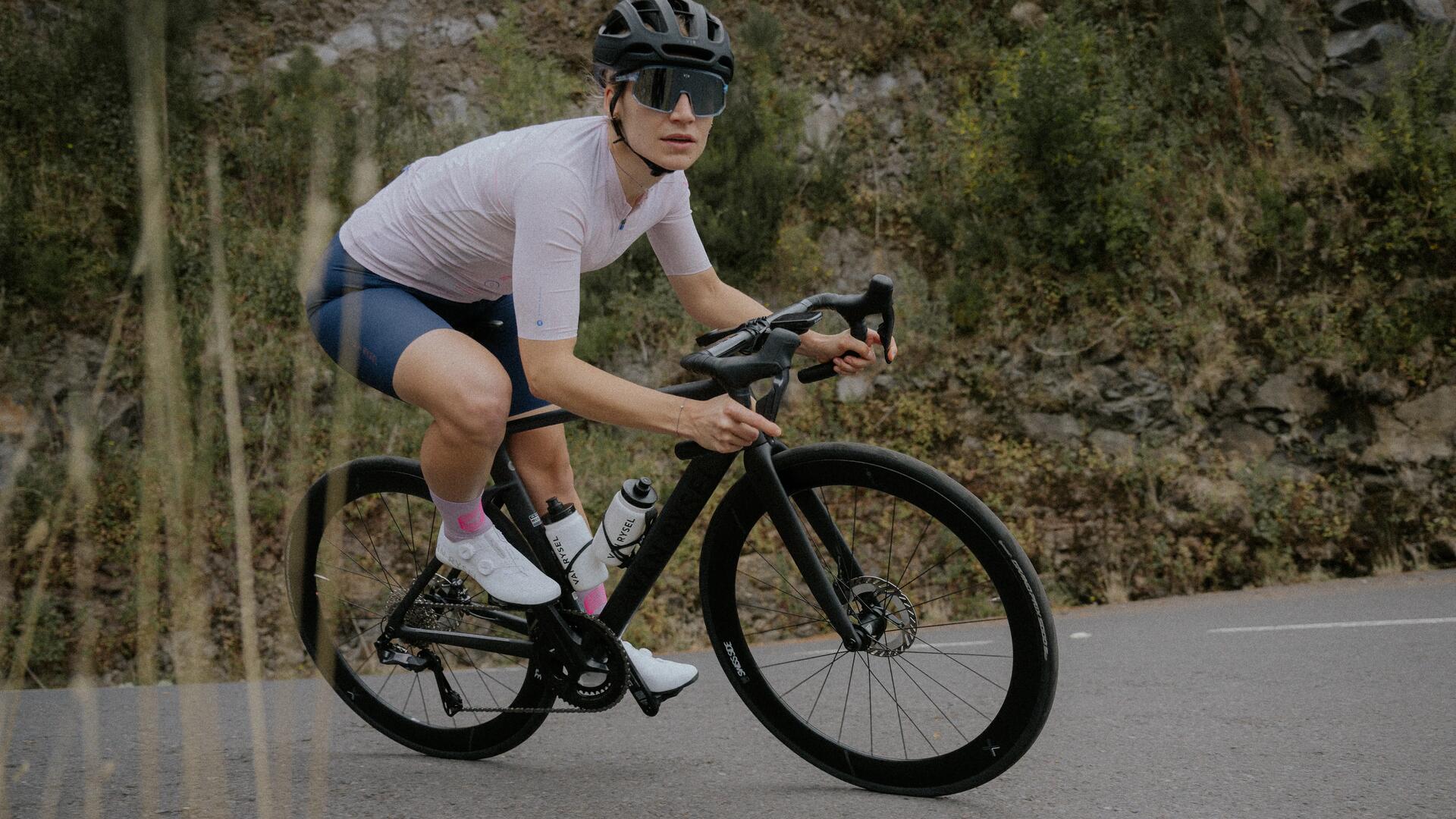 3 ciclisti in salita che bevono da borracce triban