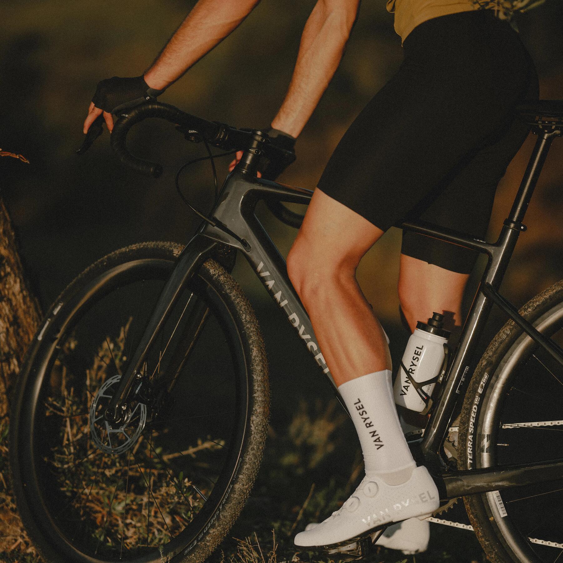 Close-up of a Van Rysel RCR bike, Van Rysel cycling shoes and water bottle.