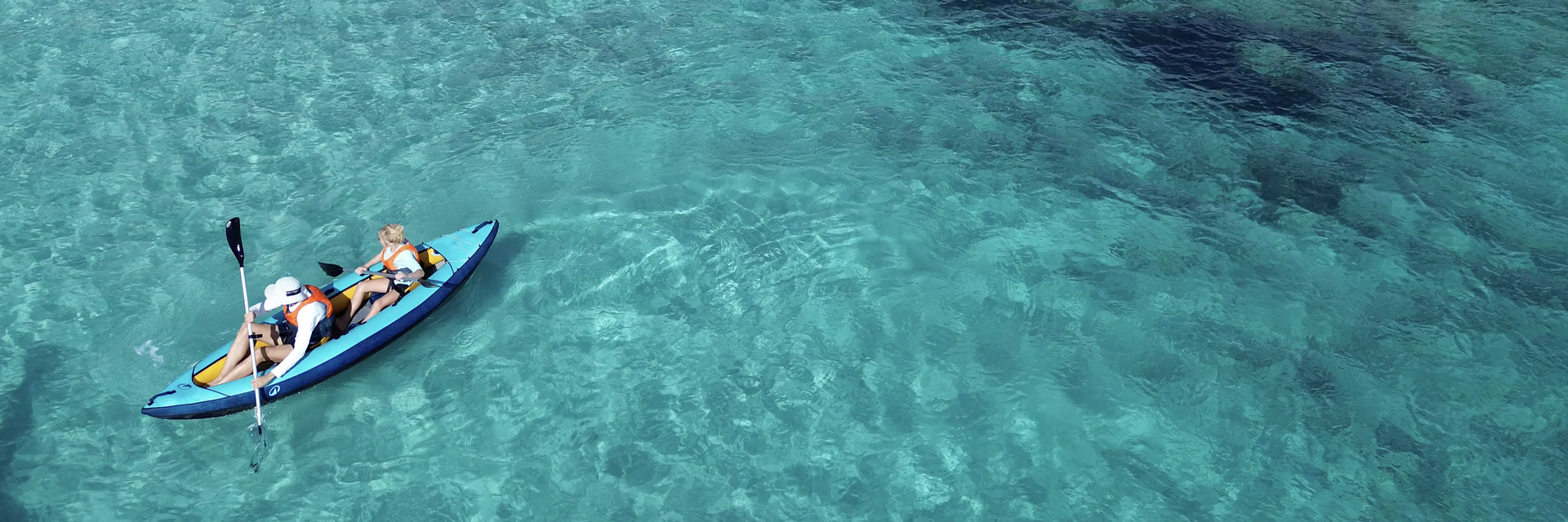 Zwei Personen fahren Kajak auf kristallklarem Wasser