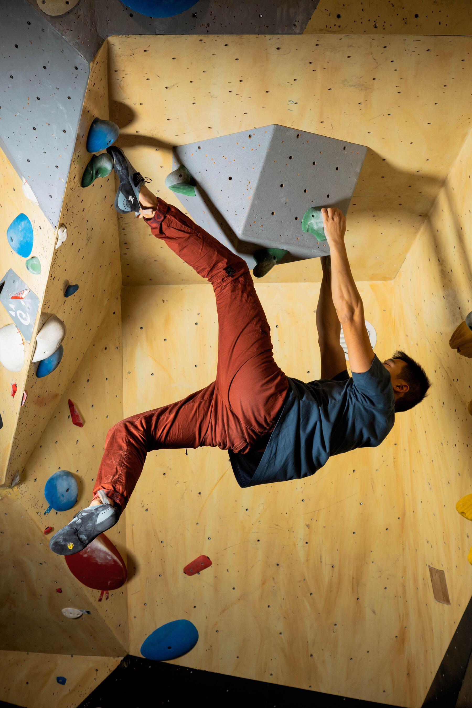Mann klettert kletter eine Indoor Kletterwand hoch