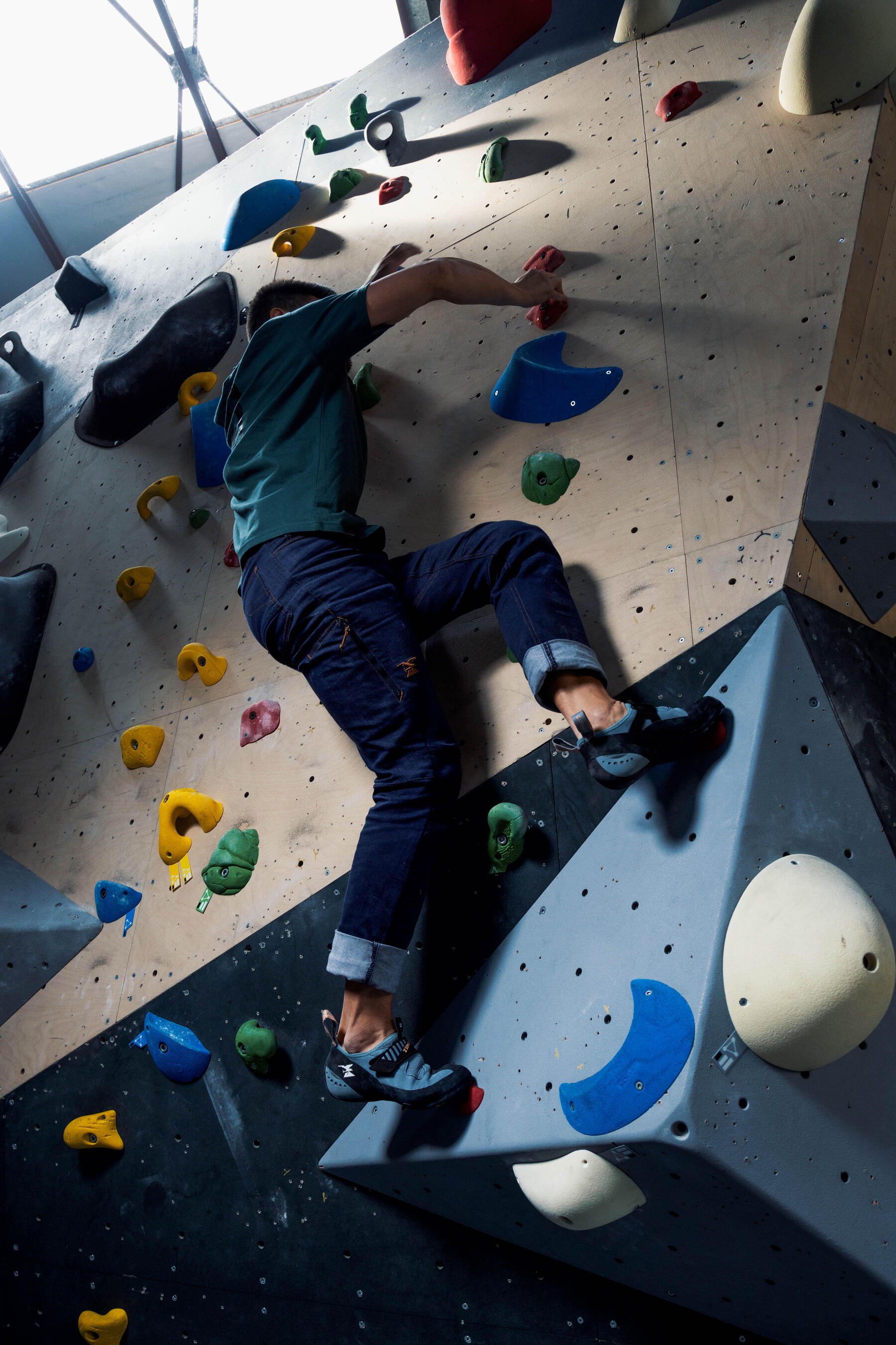 Anfänger klettert eine Indoor Kletterwand hoch