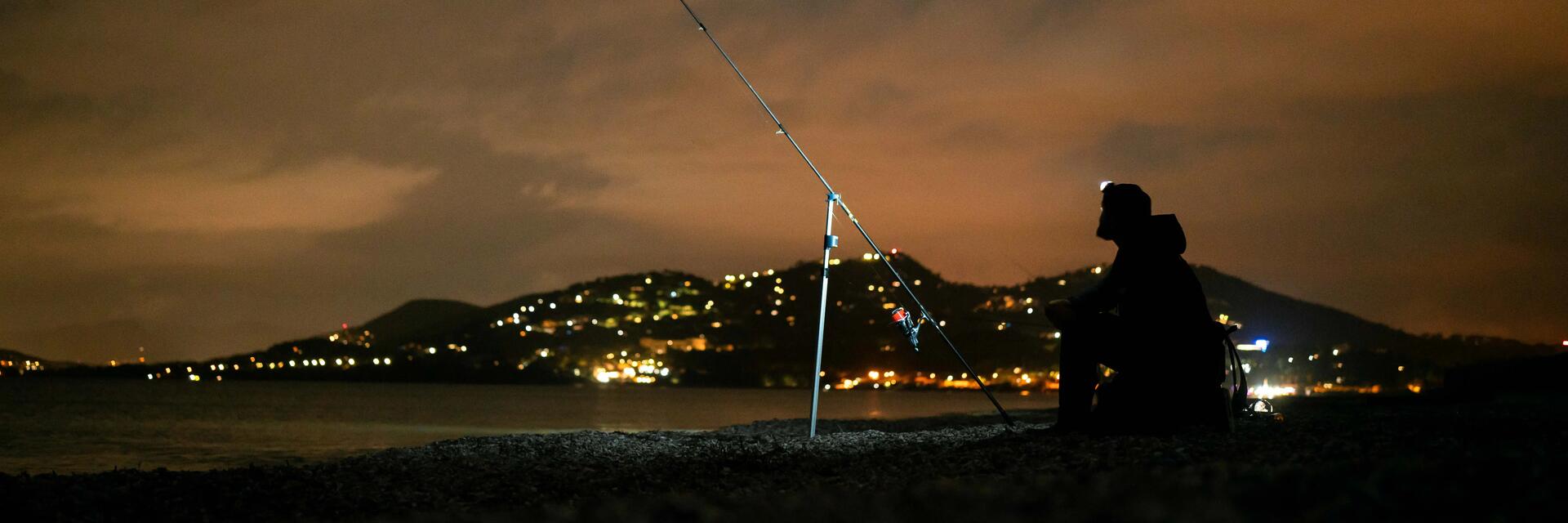 hombre practicando surfcasting de noche