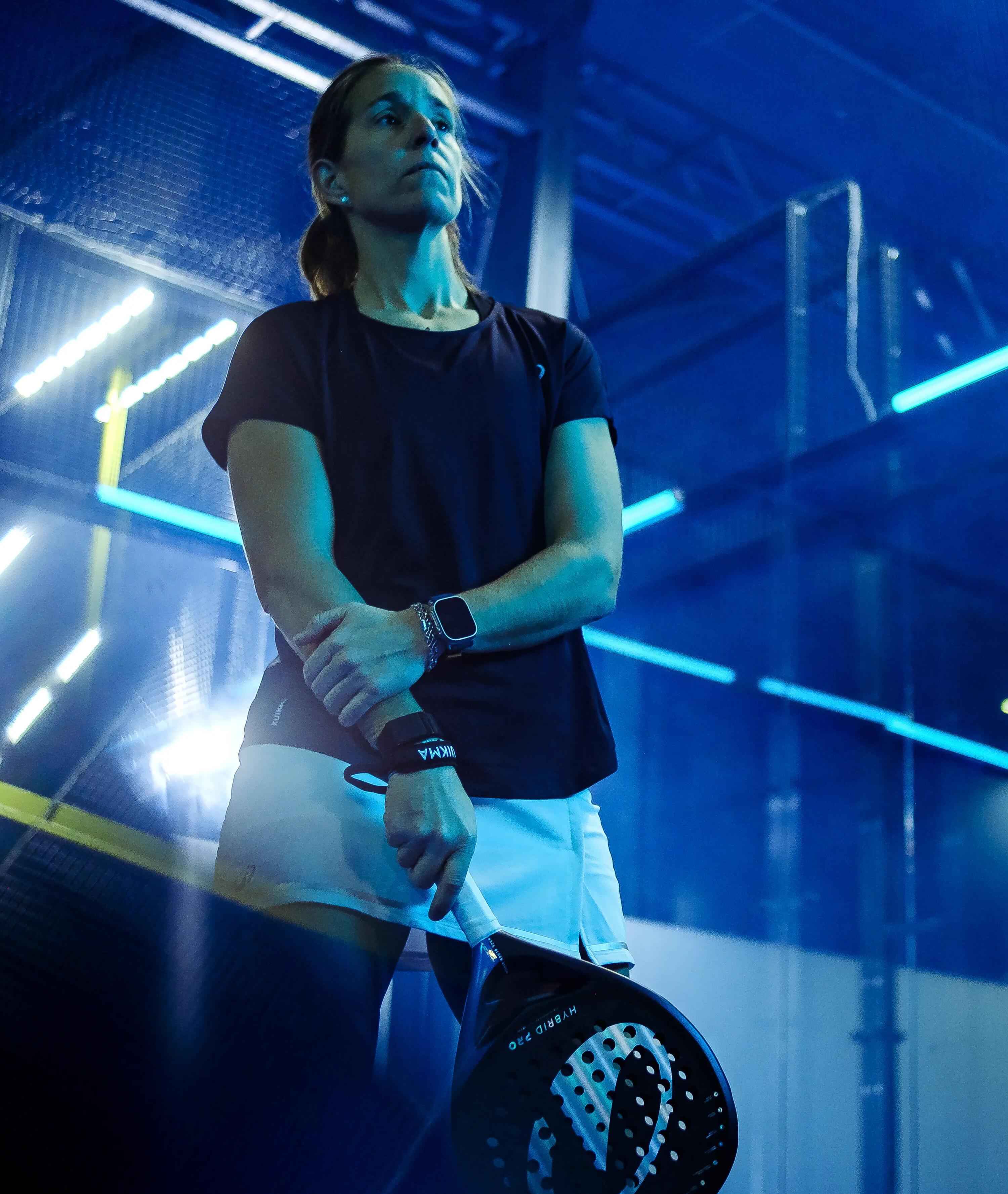 mulher com raquete de padel dentro de um campo de padel