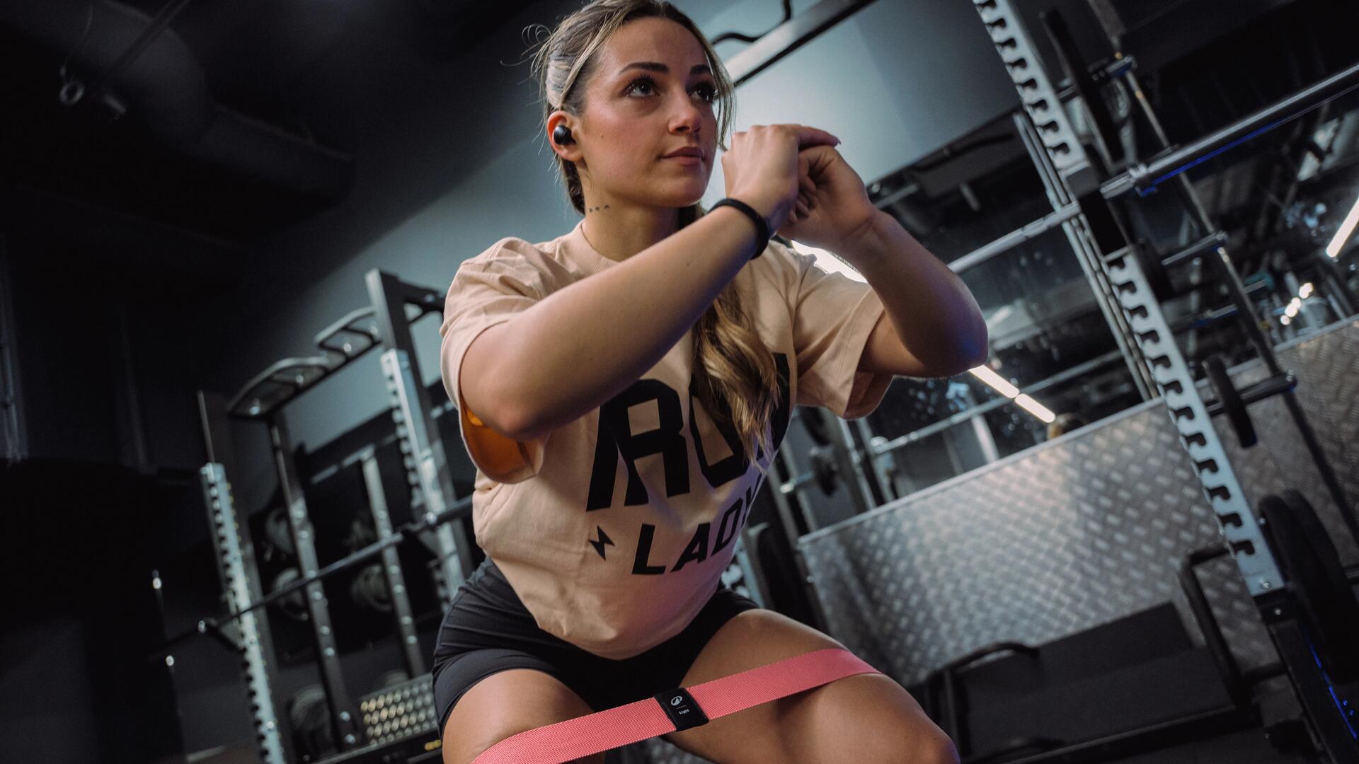 Kobieta w odzieży fitness trenująca crossfit z gumą oporową