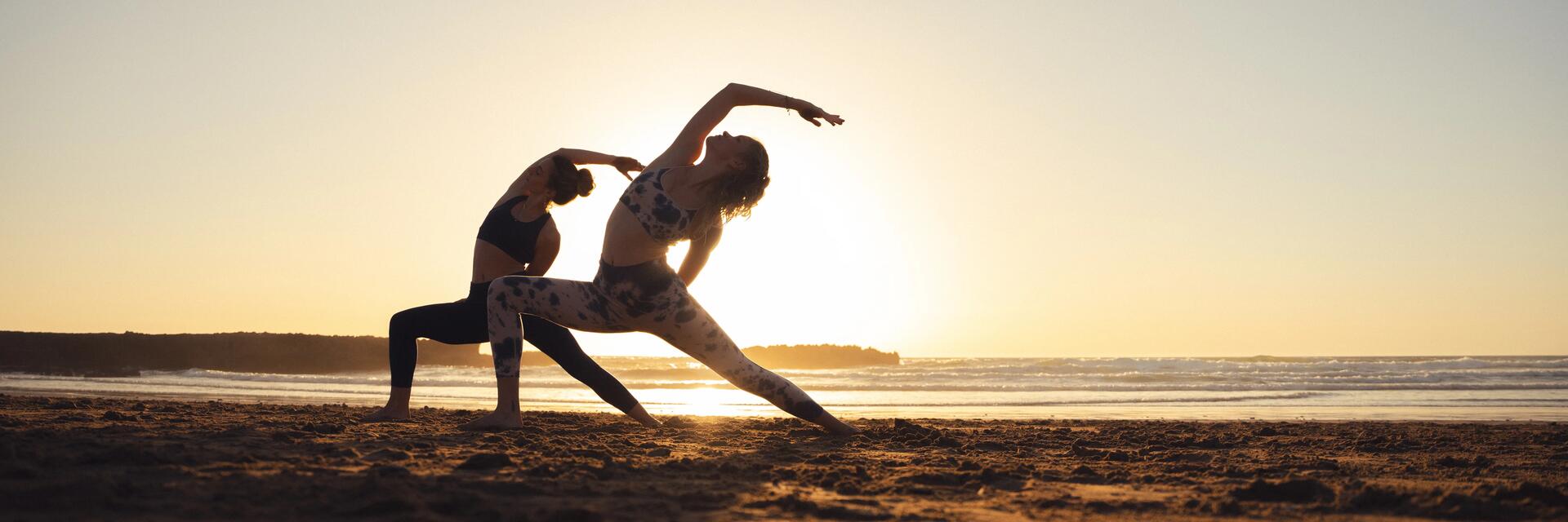 Kobiety ćwiczące pilates na stojąco na plaży