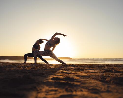 Kobiety ćwiczące pilates na stojąco na plaży