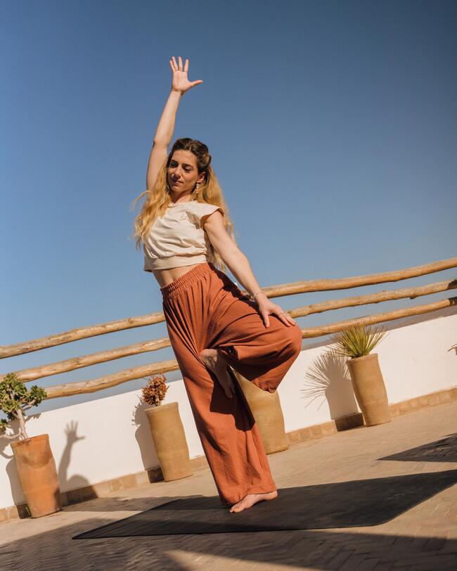 Frau macht Yoga auf einem Dach