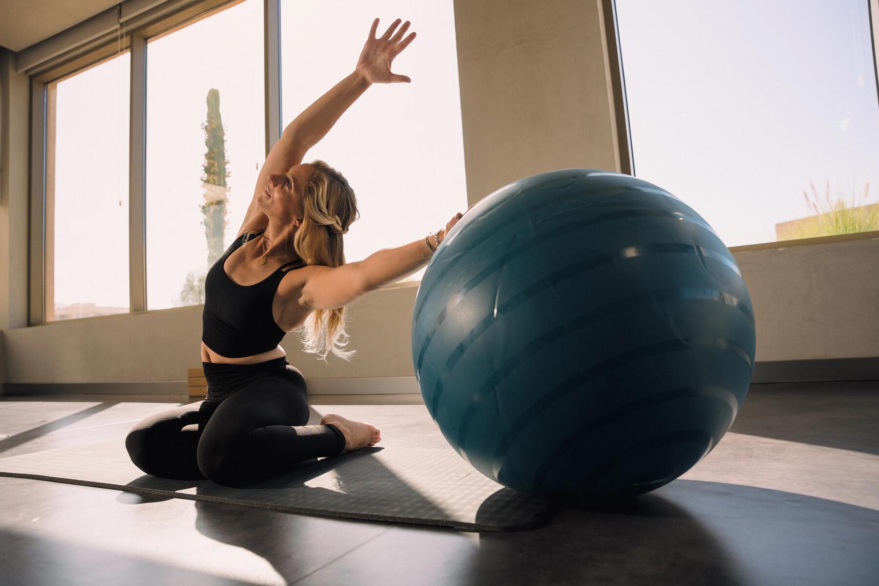 Vrouw die yoga doet met een swiss ball
