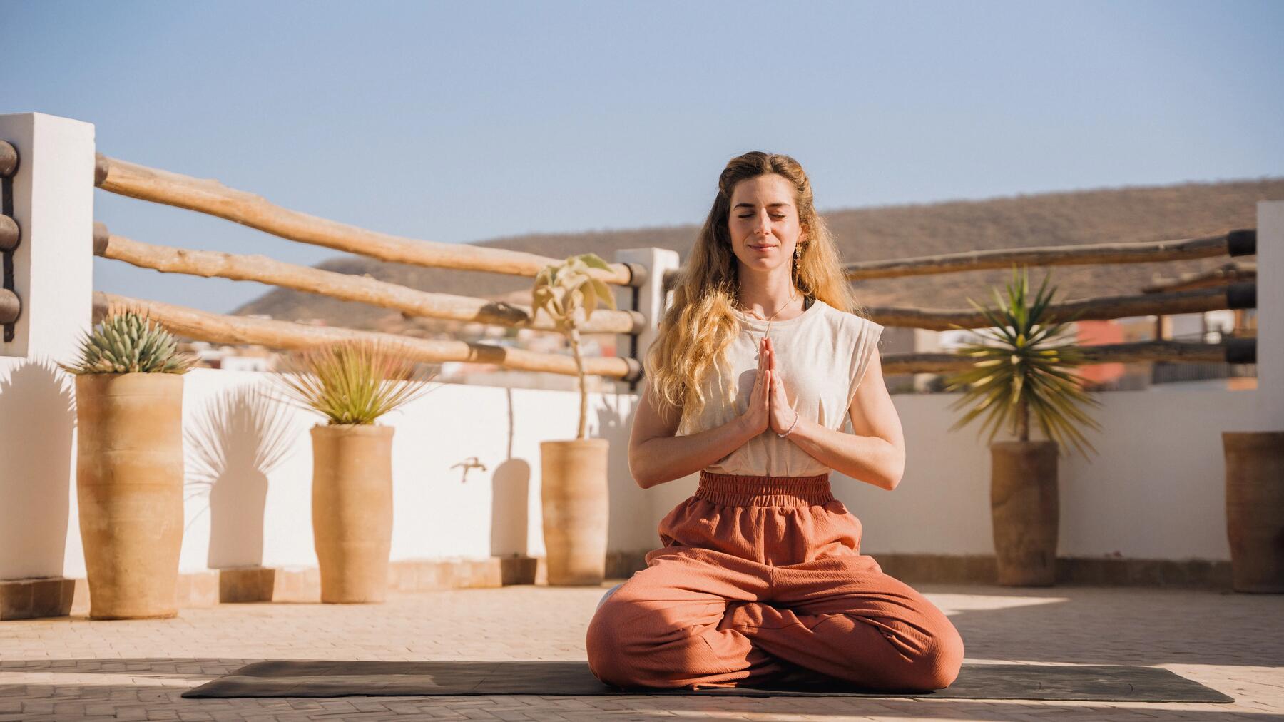 Frau auf Yogamatte übt Tantra Yoga Asana in tiefer Konzentration