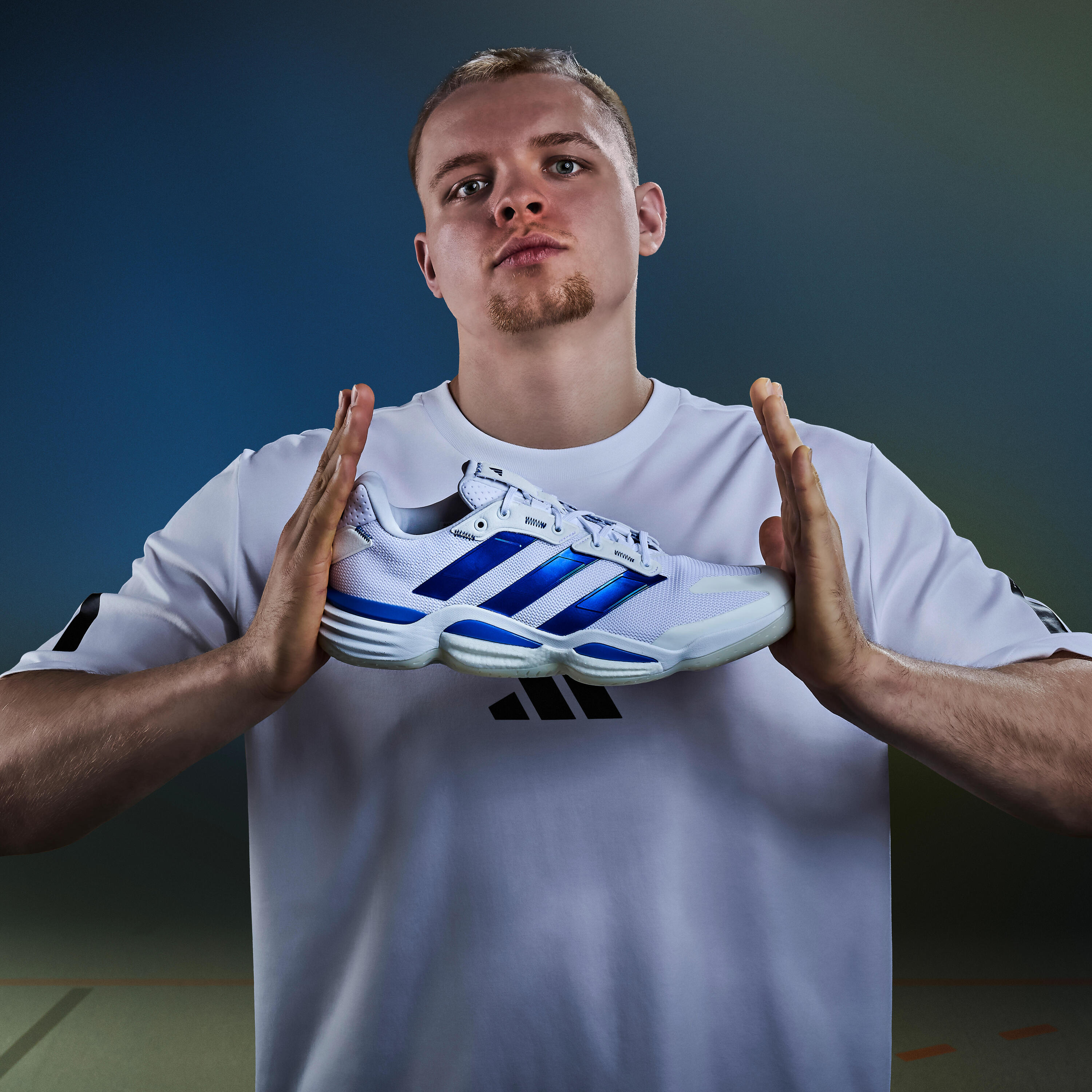 Mann hält den Handballschuh adidas Stabil 16 zwischen den Handflächen.