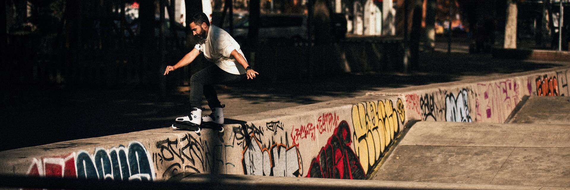 Mężczyzna na deskorolce jeżdżący po murku na skateparku