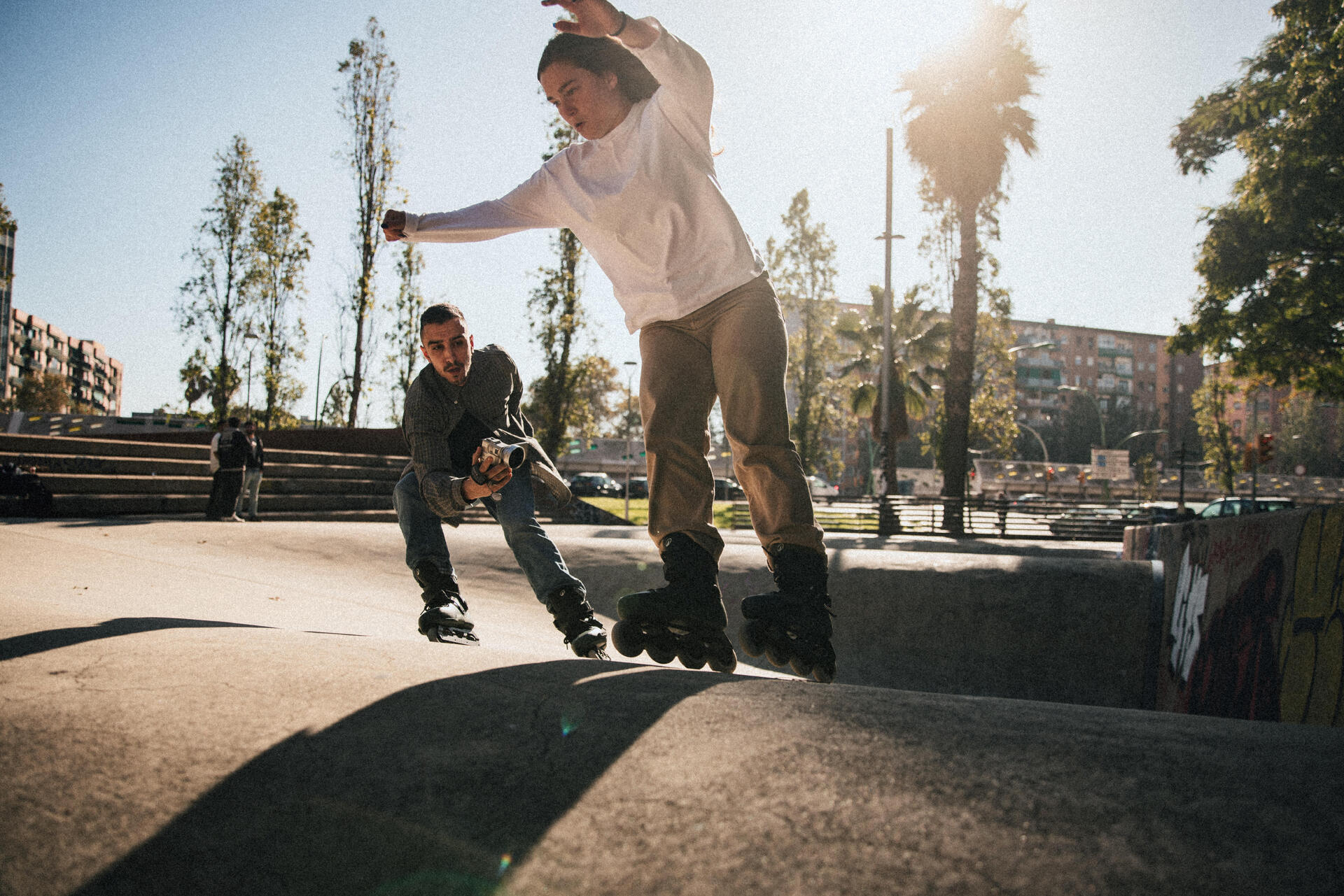 Para na rolkach jeżdżąca po skateparku