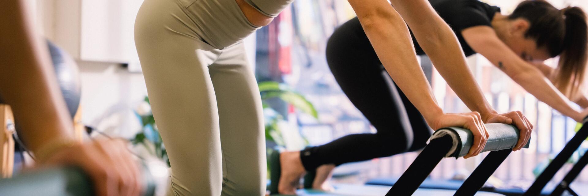 Kobiety ćwiczące pilates na reformerach