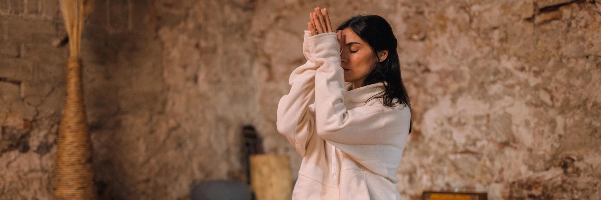Frau praktiziert Kundalini Yoga auf der Yogamatte