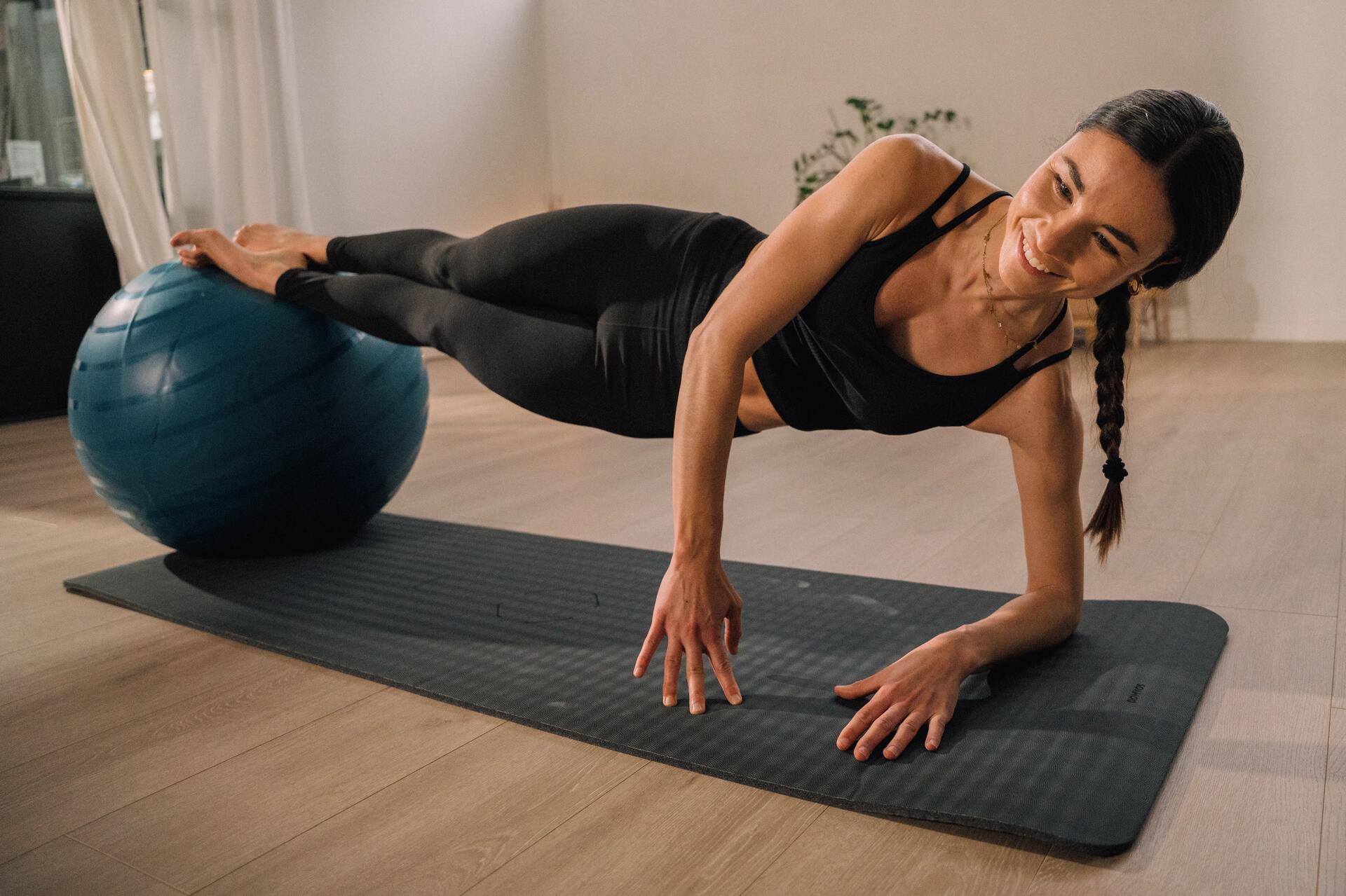 Kobieta na macie ćwicząca pilates z piłką