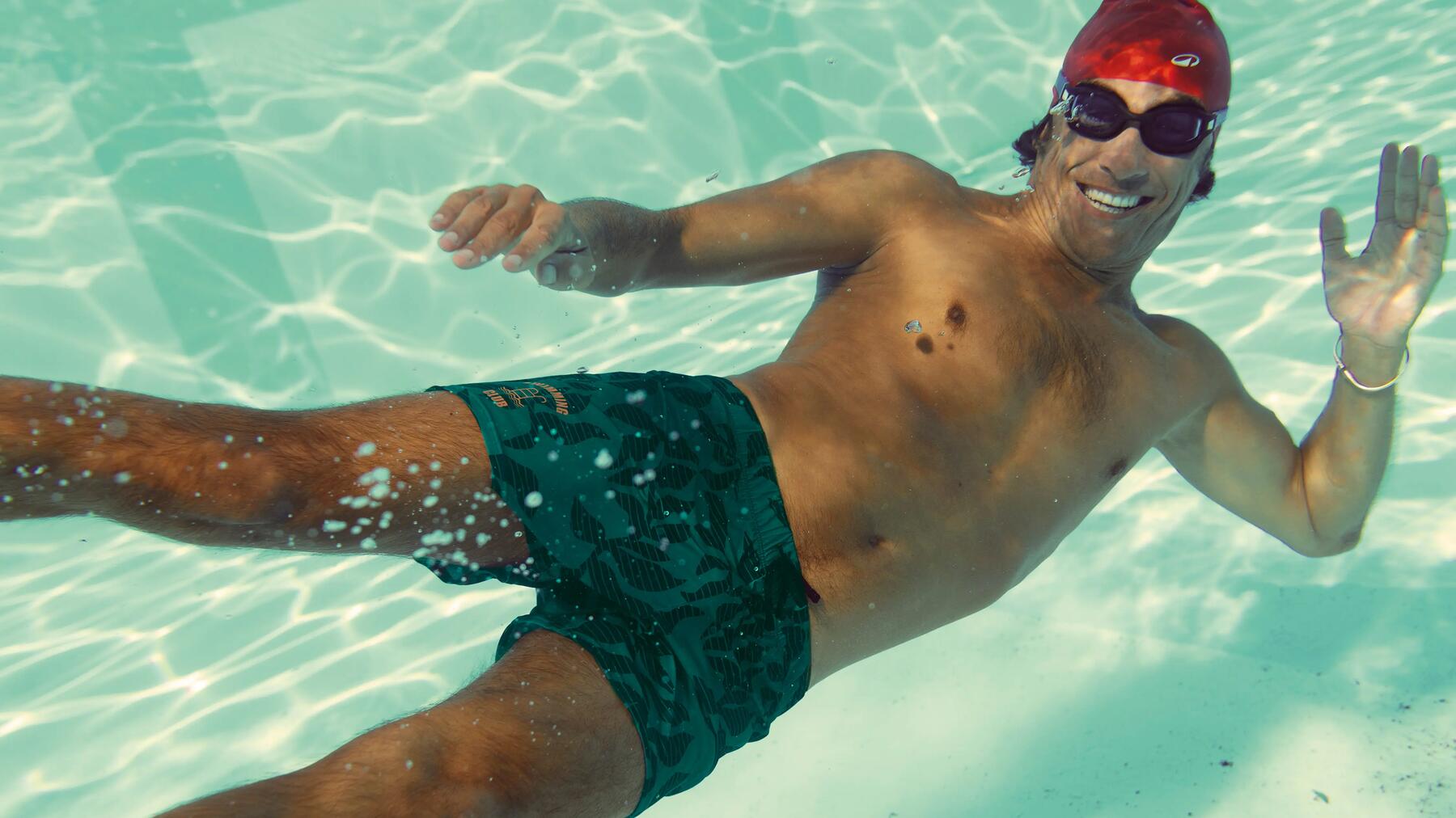Mann trägt Badekappe und Schwimmbrille