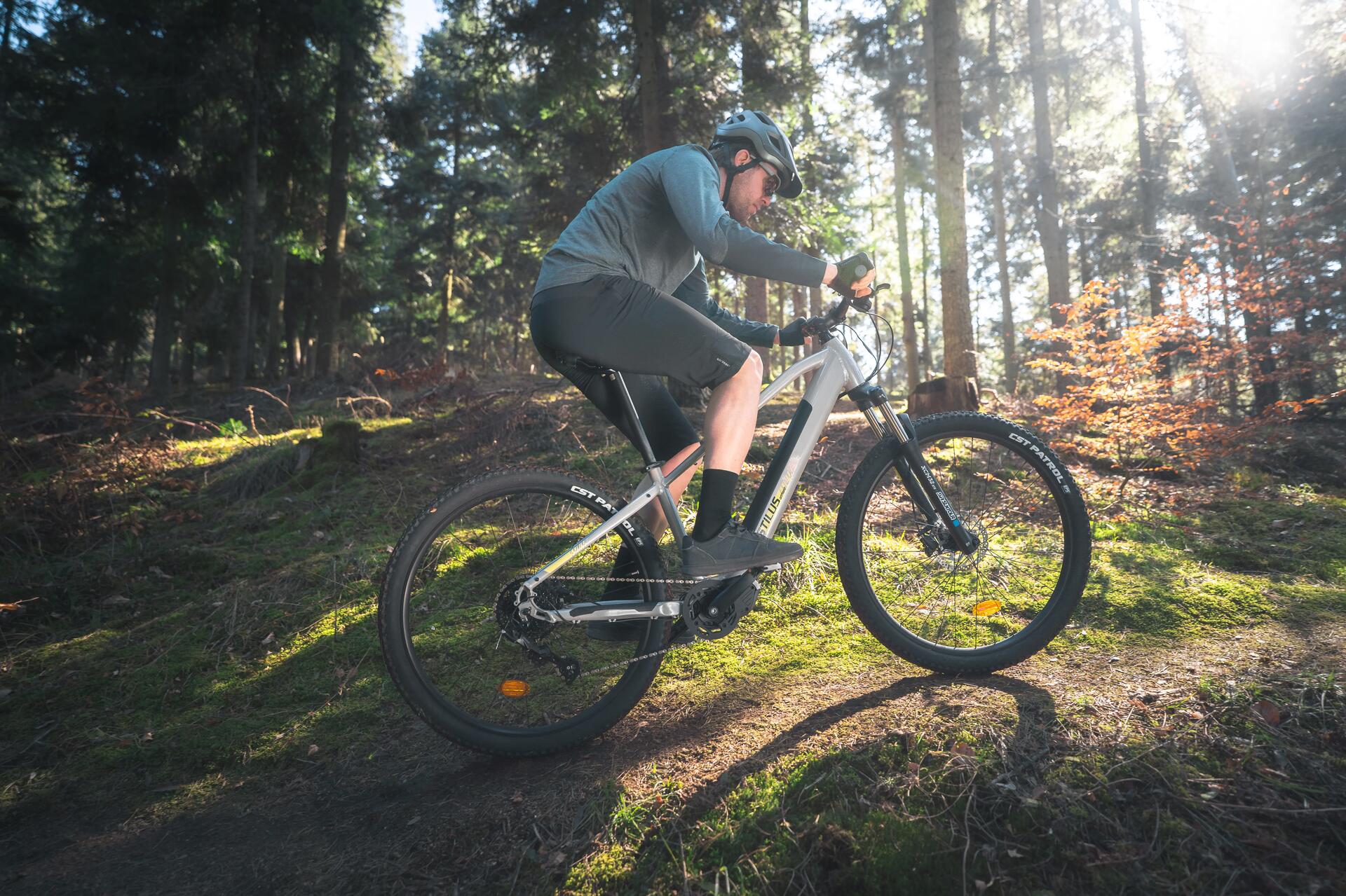 osoba w kasku i stroju rowerowym jadąca na rowerze elektrycznym  trasą przy rzece