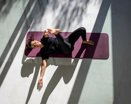 Kobieta w odzieży sportowej trenująca pilates na kręgosłup na macie do ćwiczeń