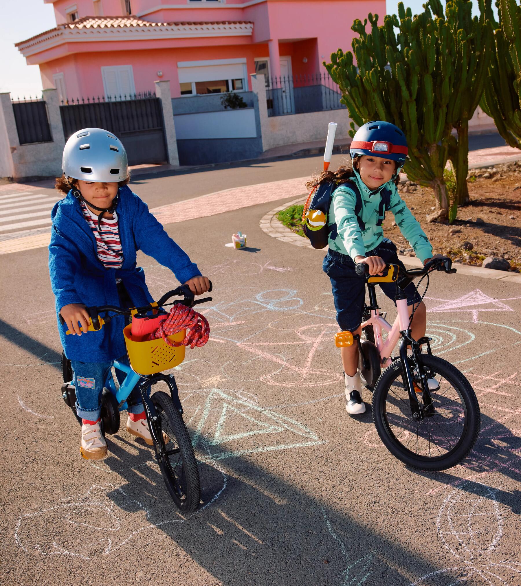 Zwei Kinder fahren mit Fahrrädern über eine Straße