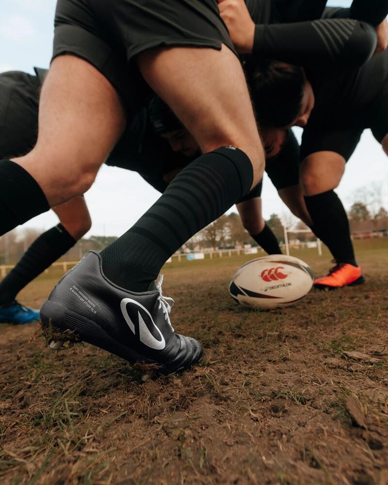 Rugbyspieler stehen sich beim Kickoff in schwarzer Kleidung gegenüber und rangeln.