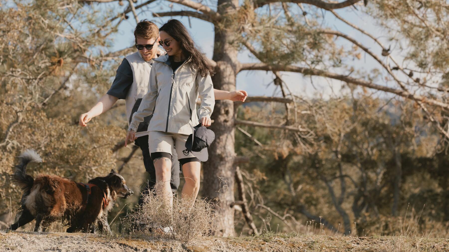 man en vrouw die wandelen in een naturgebied met de hond